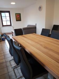 una sala de conferencias con mesa de madera y sillas en Ferienwohnung Ernesto, en Rust