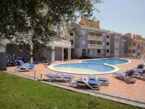 einem Pool mit Liegestühlen und einem Resort in der Unterkunft Residencial Marcomar Casa Azahar in Alcossebre