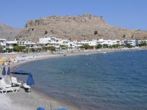 a beach with a mountain in the background at Maria Studios and Apartments in Haraki