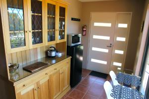 a kitchen with wooden cabinets and a black refrigerator at Ou+look BnB in Rosevears