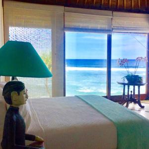 レンボンガン島にあるVilla Bahagiaのベッドルーム1室(ベッド1台、海の景色を望む窓付)が備わります。