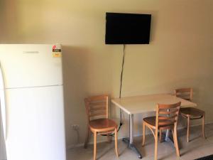 a kitchen with a table and chairs and a refrigerator at Ocean Shores Motel in Ocean Shores