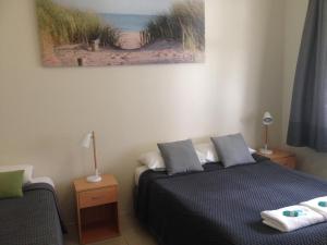 Ocean Shores Motel في أوشن شورز: غرفة نوم بسرير ودهان على الحائط