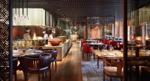 a restaurant with wooden tables and chairs and a bar at Park Hyatt Saigon in Ho Chi Minh City