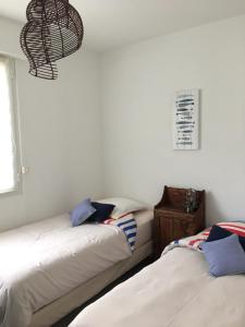 two beds sitting next to each other in a room at Villa L'Amiraute in Agde