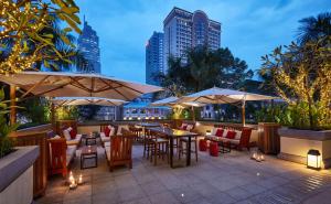 a patio with tables and chairs and umbrellas at Park Hyatt Saigon in Ho Chi Minh City