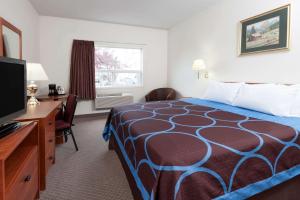 a hotel room with a bed and a flat screen tv at Super 8 by Wyndham Edmonton/West in Edmonton