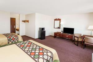 a hotel room with two beds and a flat screen tv at Super 8 by Wyndham Lincoln in Lincoln