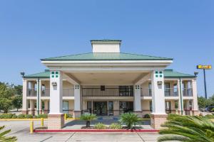 a large building with a green roof at Super 8 by Wyndham Slidell in Slidell