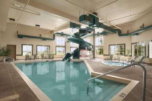 a indoor swimming pool with a slide in a building at Super 8 by Wyndham Fort St. John BC in Fort Saint John