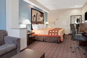 a hotel room with a bed and a desk at Super 8 by Wyndham Houston North I-45 in Houston