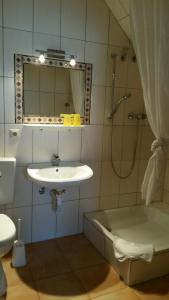a bathroom with a sink and a shower with a mirror at Hotel Gasthof Ratstube in Kirchheim unter Teck