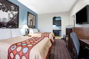 Habitación de hotel con 2 camas y TV de pantalla plana. en Super 8 by Wyndham Houston North I-45, en Houston
