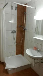 a bathroom with a shower and a sink at Hotel Gasthof Ratstube in Kirchheim unter Teck +2 photos