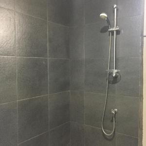 a shower with a shower head in a bathroom at Cempaka Homestay in Uluwatu