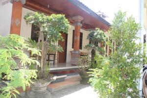 a house with a porch with plants in front of it at JS Guest House in Seminyak