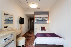 a hotel room with a bed and a tv at Ryogoku View Hotel in Tokyo