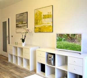 a living room with a tv on a white dresser at F2 - Am alten Elbarm - Laubegast in Dresden
