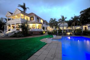 
a large pool of water in front of a house at Audacia Manor Boutique Hotel in Durban

