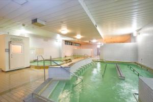 a pool of water in a gym with a swimming pool at Sakudaira Plaza 21 in Saku