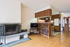 a living room with a fireplace and a television at Appartementhaus-Quadern in Valens +28 photos