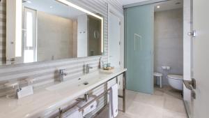 a bathroom with a sink and a toilet and a mirror at ESTIMAR Calpe Suitopia in Calpe