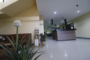 a lobby with a reception desk and a plant at RedDoorz near ITC Cempaka Mas in Jakarta
