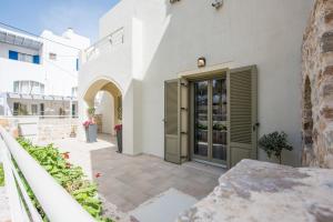 a white building with a door on a patio at Platinum in Kamari