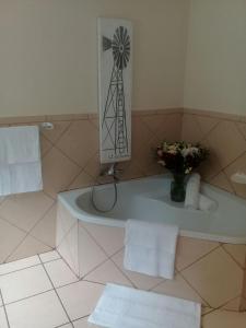 a bathroom with a bath tub with a windmill on the wall at Shalamanzi Lodge in Hartbeespoort