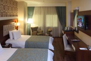 a hotel room with two beds and a desk at Hotel Senbayrak City in Adana +44 photos