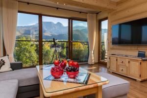 a living room with a table with bowls of fruit on it at Polana Szymoszkowa Ski Resort in Zakopane