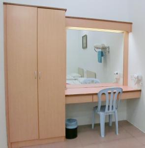 - un dressing avec une chaise et un miroir dans l'établissement KT Beach Resort, à Kuala Terengganu