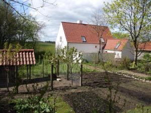 a garden with a fence and a white house at Natursti Silkeborg Bed & Breakfast in Them +14 photos