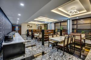 a restaurant with tables and chairs in a room at Hotel Ma Grand in Pudukkottai