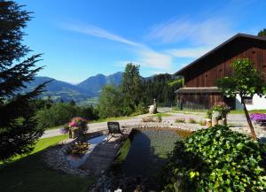 a bench sitting next to a pond in front of a barn at Hinterburgschwaig Hof in Sankt Johann im Pongau