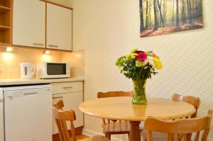 a vase of flowers sitting on a table in a kitchen at Crags View Apartment On The Royal Mile in Edinburgh