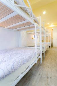 花蓮市的住宿－花蓮鳥窩青年旅舍，一间卧室设有两张双层床,铺有木地板。