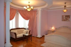 a bedroom with a bed and a chair and a window at Apartment Dynasty in Novosibirsk