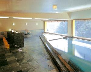 a swimming pool in a building with a swimming pool at Nishiyama Onsen Keiunkan in Hayakawa