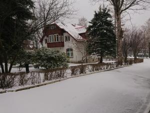 a house covered in snow in front of a street at DW Bukówka in Karpacz