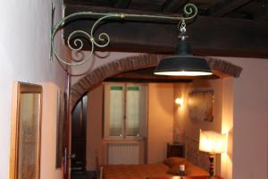 aendant light hanging in a room with a table at La Fiera Vecchia Apartments in Meleto