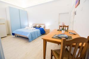 ein Schlafzimmer mit einem Bett und einem Holztisch mit einem Esszimmer in der Unterkunft Dimore dei Marinai Termoli in Termoli