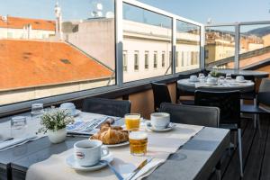 a table with plates of food and drinks on a balcony at Hotel De Suède in Nice
