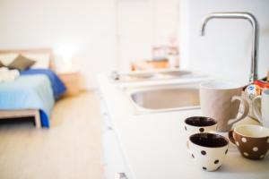 eine Küchentheke mit zwei Tassen und einem Waschbecken in der Unterkunft Dimore dei Marinai Termoli in Termoli + 35 Fotos