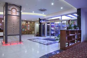 a lobby with a clock in the middle of a building at Hotel Senbayrak City in Adana