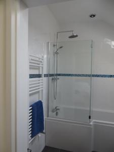 a bathroom with a shower with a glass door at The Pigsty in Ashbourne