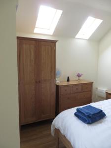 a bedroom with a bed and a dresser and skylights at The Pigsty in Ashbourne