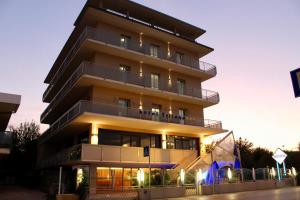 a building with a sign on the side of it at Hotel Tritone Rimini in Rimini