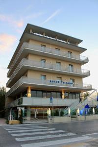 a tall building with a sign on the side of it at Hotel Tritone Rimini in Rimini