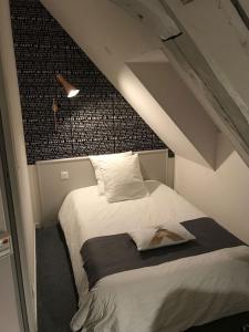 Saint-Bonnet-Tronçais的住宿－勒托才思酒店，阁楼上的卧室配有一张大床
